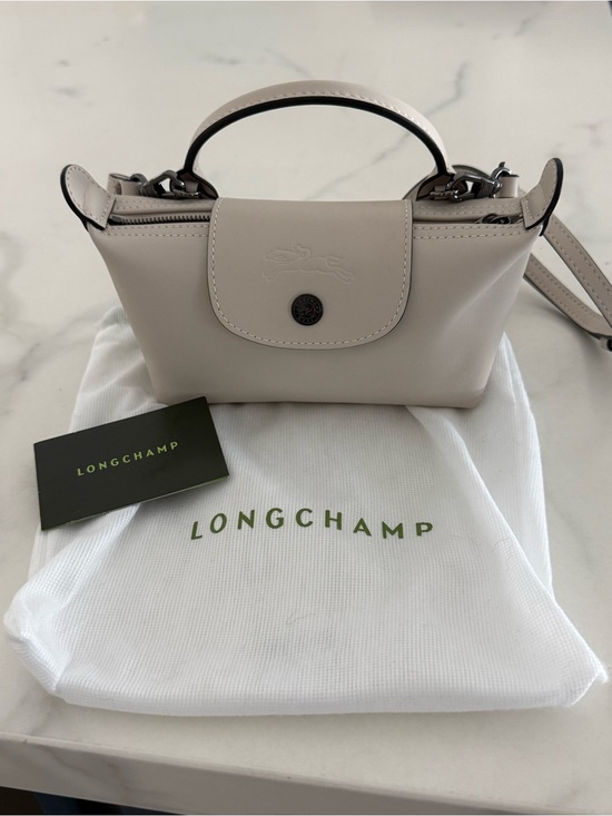 Longchamp Handbags - Longchamp Extra Small Le Pilage leather clutch with strap in light beig